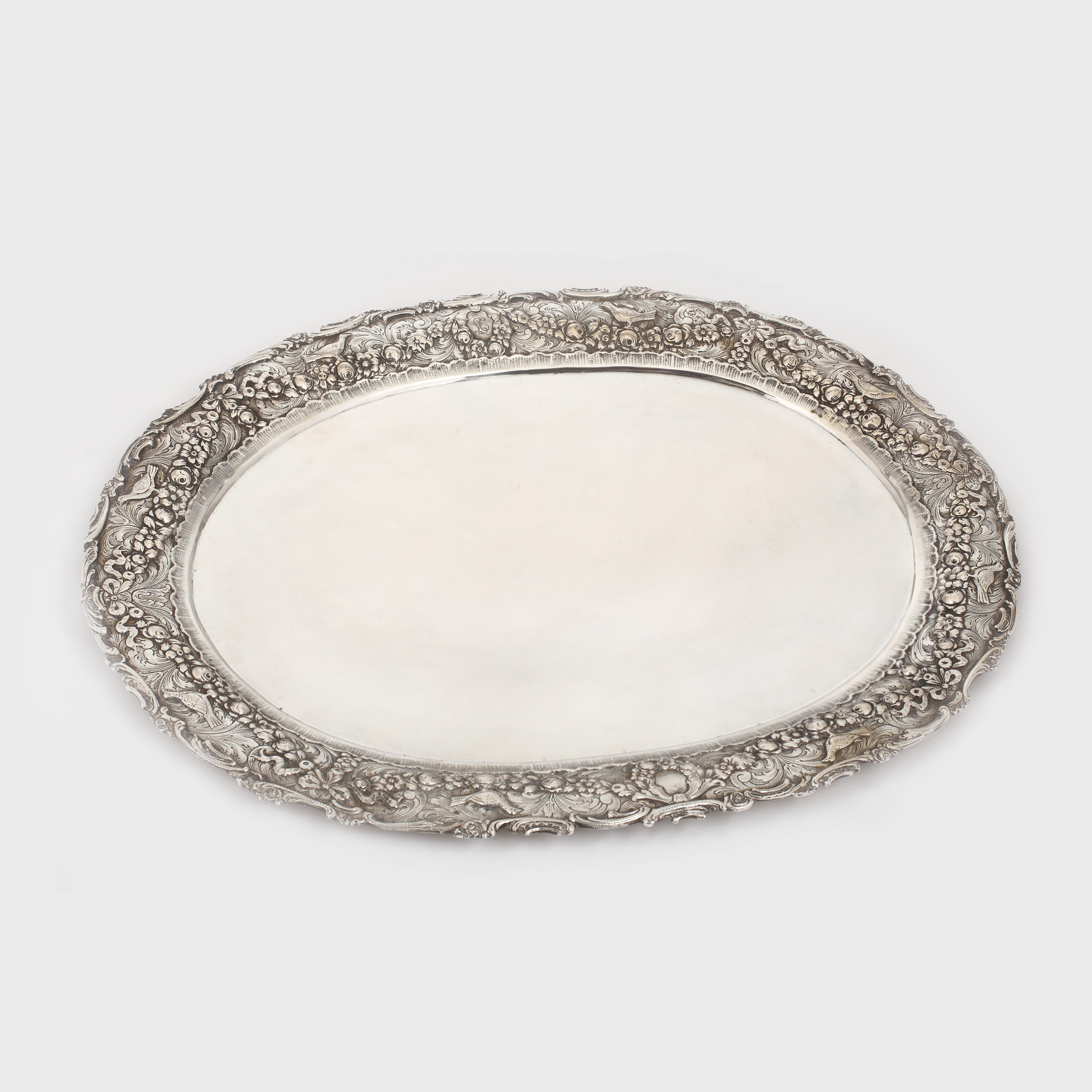 Tavă din argint Hanau, monogramată, cu bordură amplu decorată cu flori și păsări, cca. 1900-1920