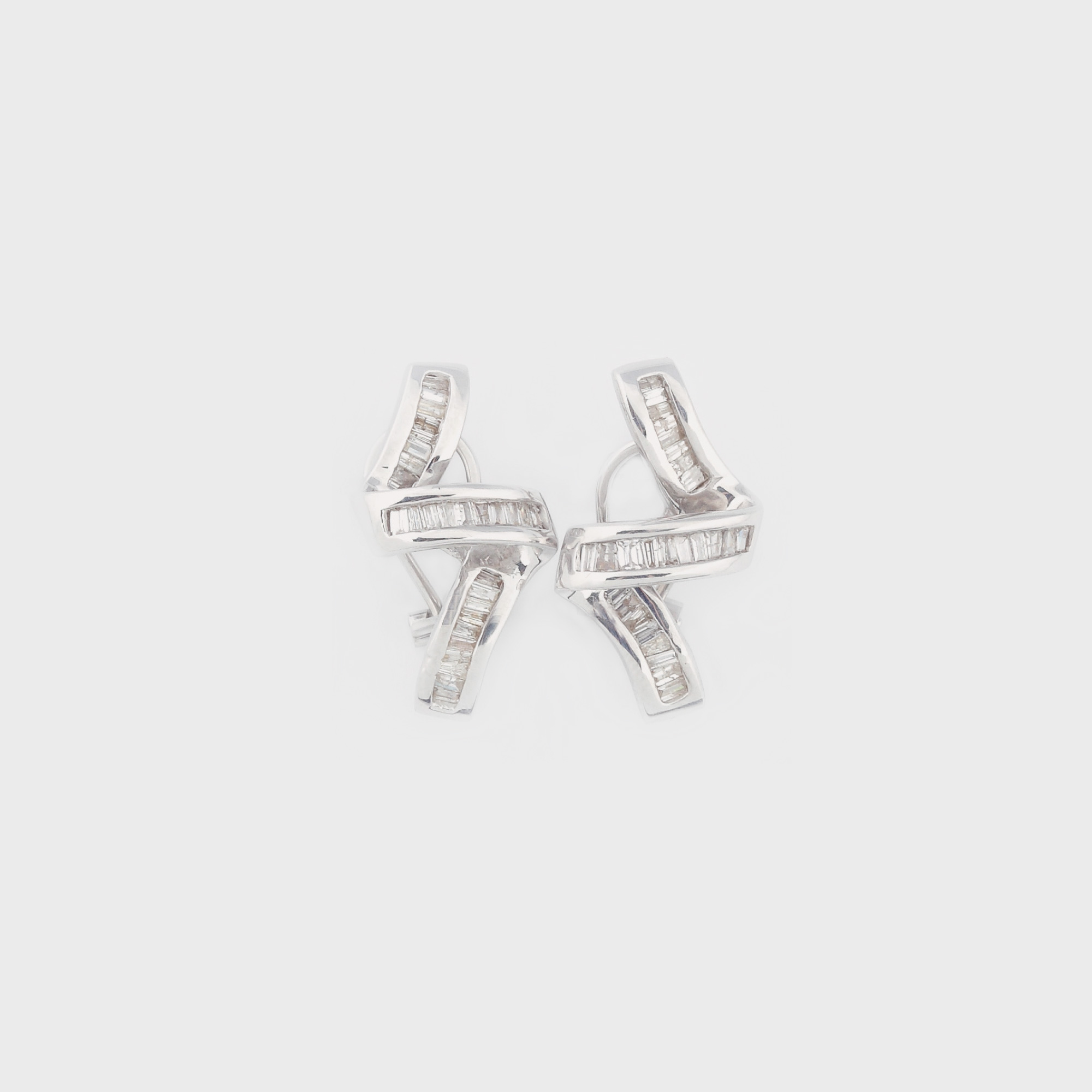 Interesantă pereche de cercei din aur alb, decorată cu baghete de diamant