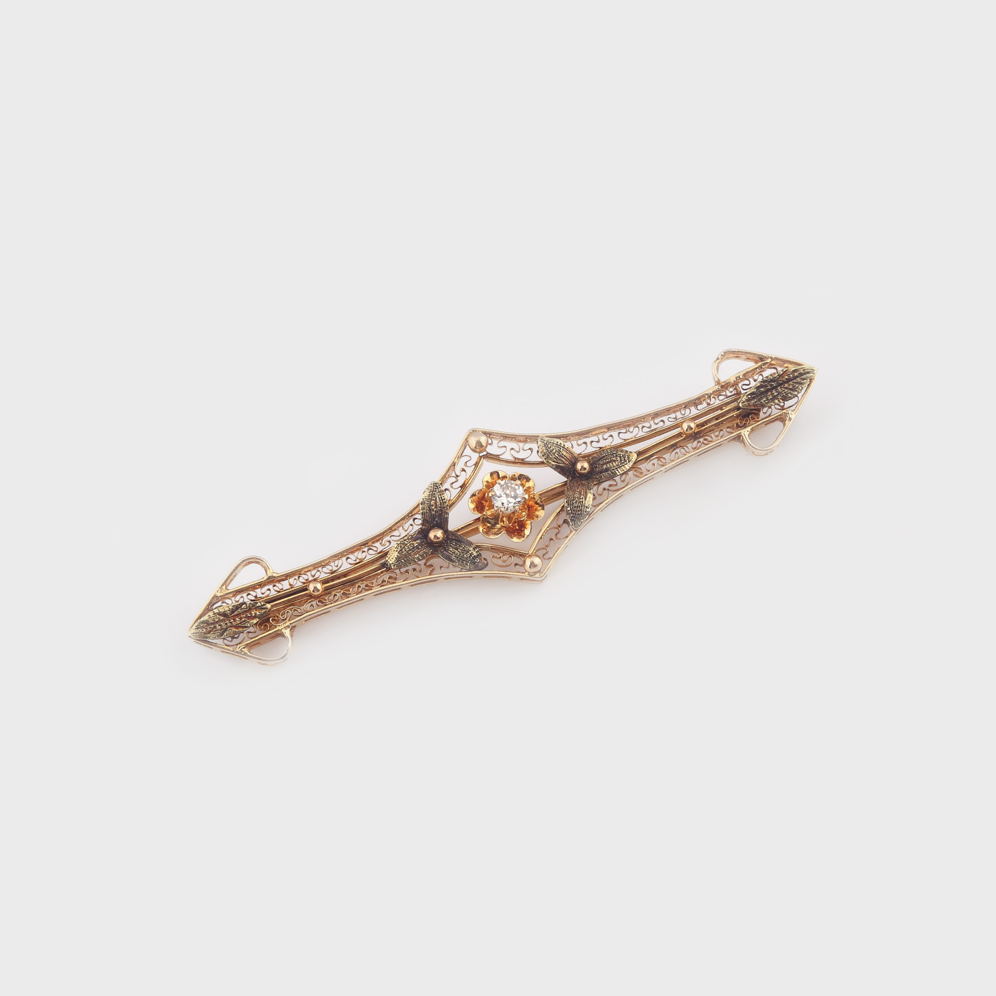 Elegantă broşă din aur, decorată cu diamant central şi ornamentaţii în filigran