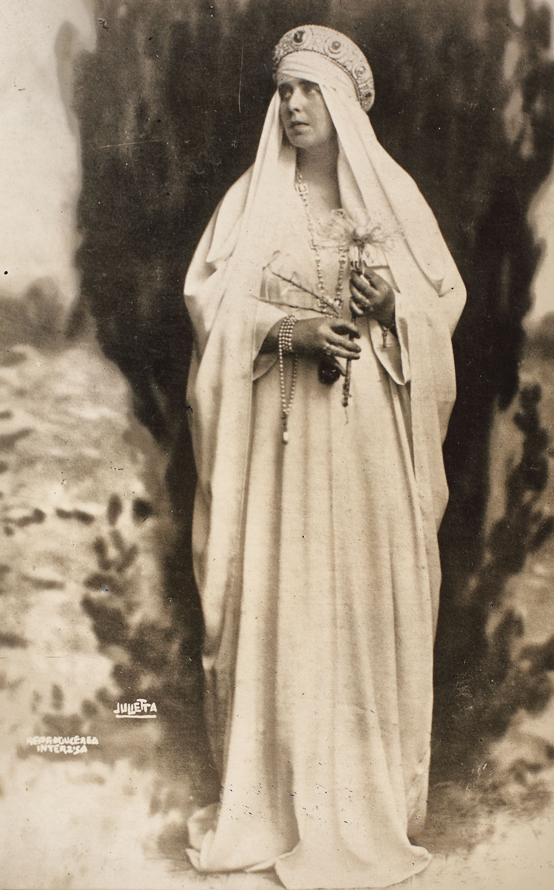  Fotografie ilustrând-o pe Regina Maria în costum celtic, ținând în mână o floare de crin, cca. 1923