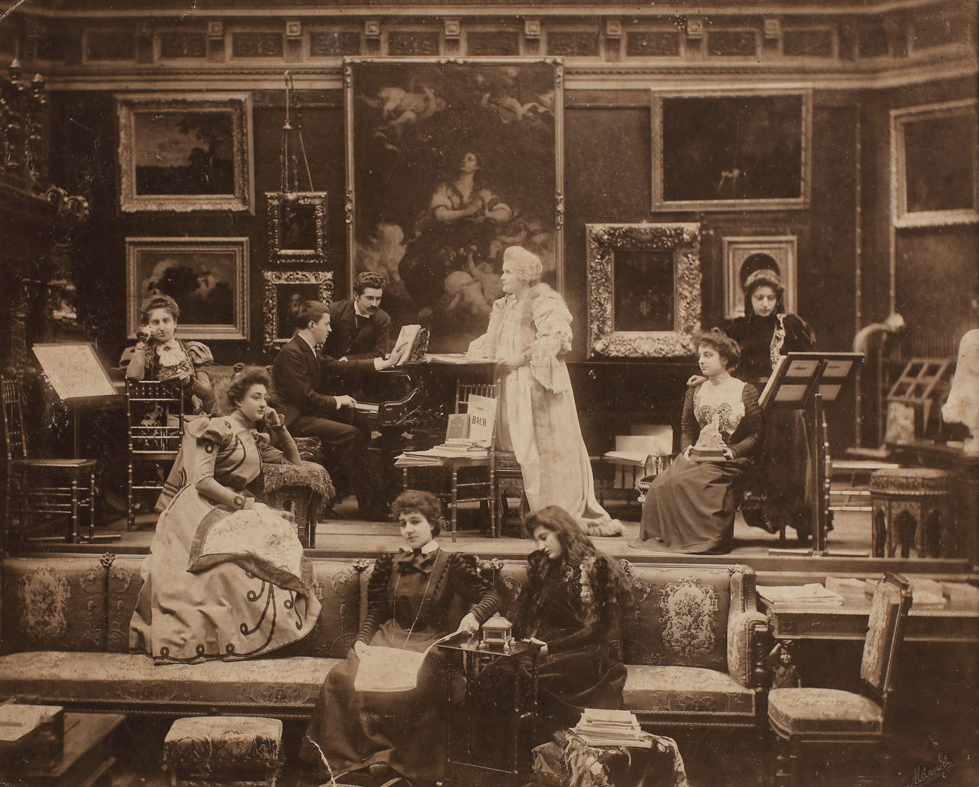 Fotografie de colecţie înfăţişând-o pe Regina Elisabeta alături de George Enescu şi Grigoraş Dinicu, doamnele de onoare, la o serată muzicală, la palatul regal, cca. 1898