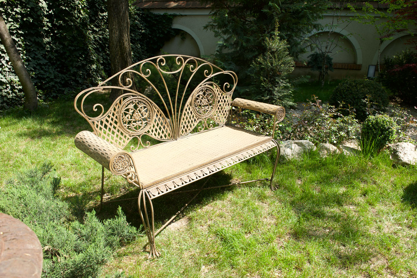 Vintage garden bench, the back ornate with floral motifs and dragonflies
