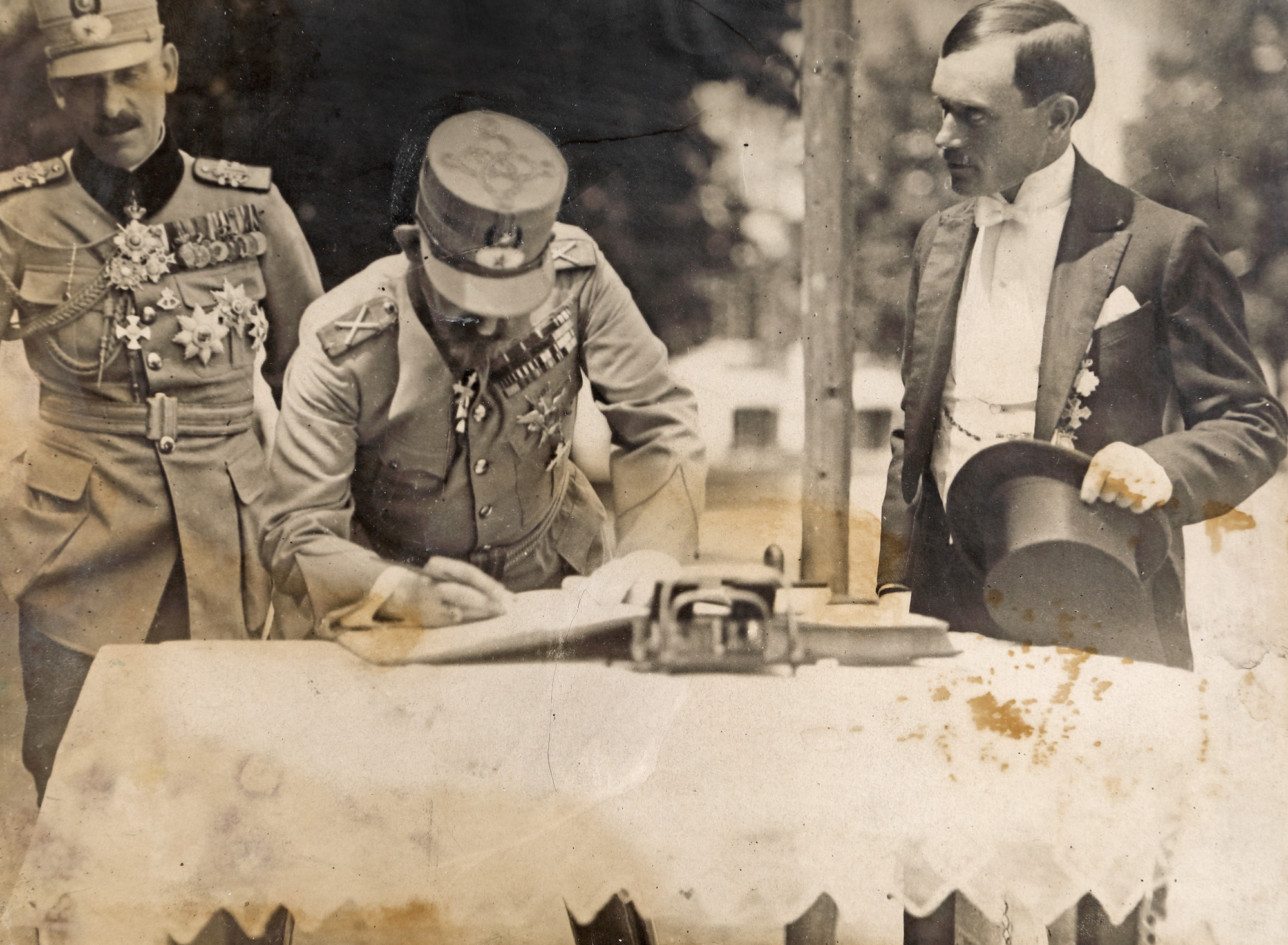 Fotografie ilustrându-l pe Regele Ferdinand într-un moment solemn, semnând într-o carte de onoare, cca. 1920