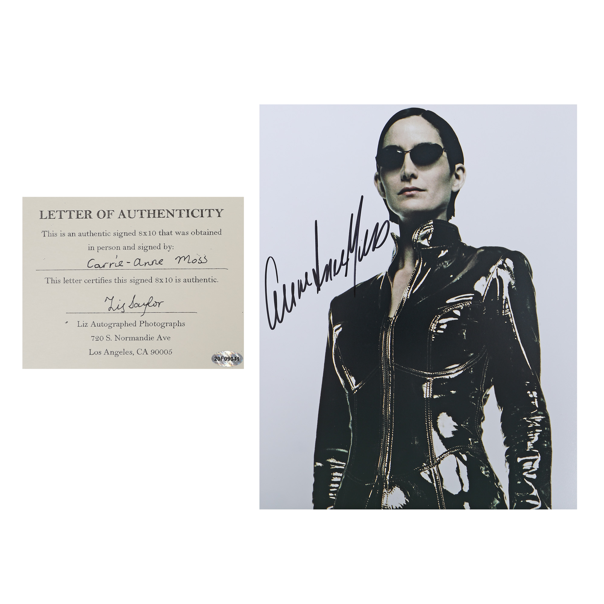 Fotografie ilustrând-o pe Carrie Ann Moss, în rolul Trinity din seria The Matrix, cu semnătura olografă a actriței, însoțită de certificatul de autenticitate
