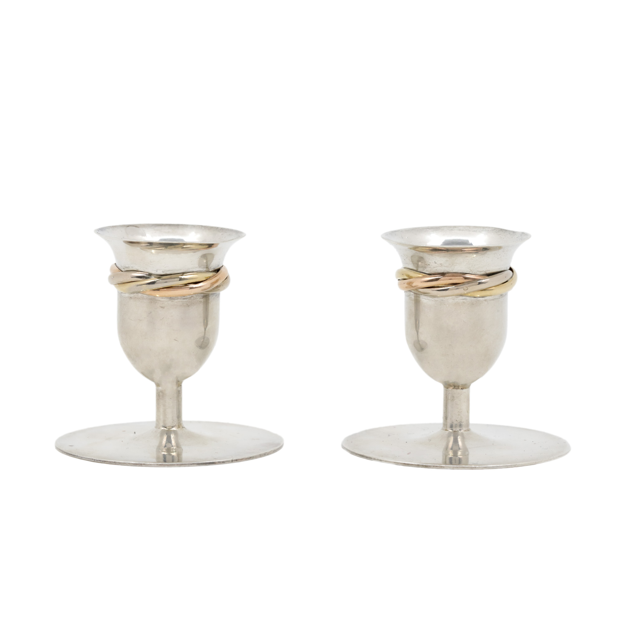 "Trinity" - Lot consisting of two Cartier candlesticks, made of silver, decorated with two-tone gold