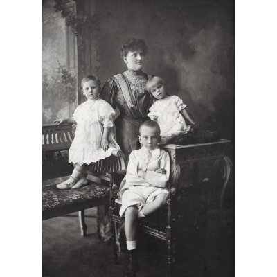 Melancholic typical family photograph from the end of the century, a mother with her three children, circa 1900