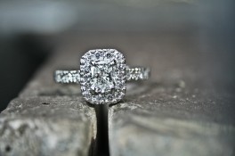 A CUSHION CUT HALO STYLE DIAMOND RING WITH SHOULDERS SET