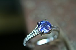 BRILLIANT CUT SAPPHIRE WITH GRAIN SET DIAMOND SHOULDERS