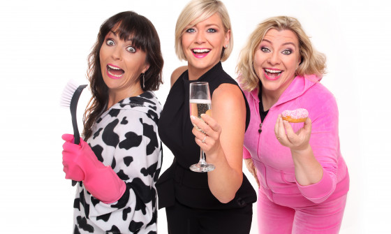 A close up of Hormonal Housewives holding wine glasses. The one on the left is in cleaning attire, the one in the middle is dressed in formalwear and the one on the right is dressed up in a tracksuit.