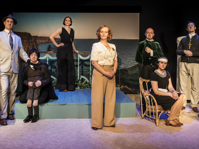 The cast of Crimes on the Coast sit in costume aboard a deck