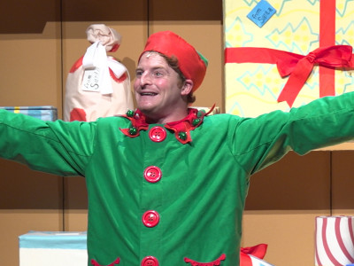 An elf extends his arms outwards on display