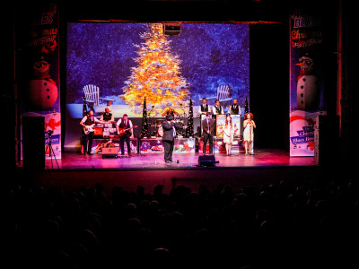 A full shot of the stage. A big Christmas tree takes the backdrop.