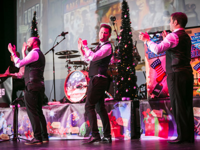 Three members of The Chicago Blues Brothers clap in unison
