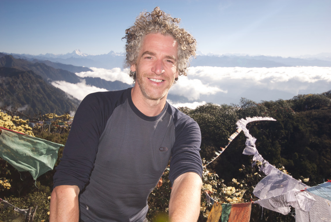 Gordon Buchanan stands in front of a mountainous region