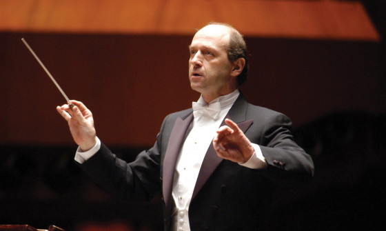 Iván Fischer is holding a batton, conducting