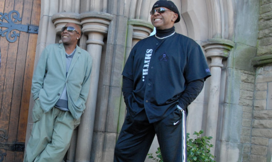 Chris Amoo and Dave Smith stand looking beyond the camera, smiling.