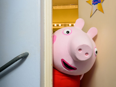 Peppa Pig pokes her head out from in her dressing room