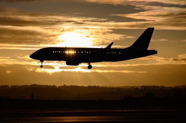 Silhouette of an airplane against the background of an orange evening sky
