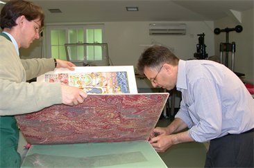 Two craftsmen putting together the Book of Benefactions