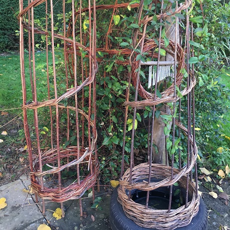 Two tall willow structures for growing plants up