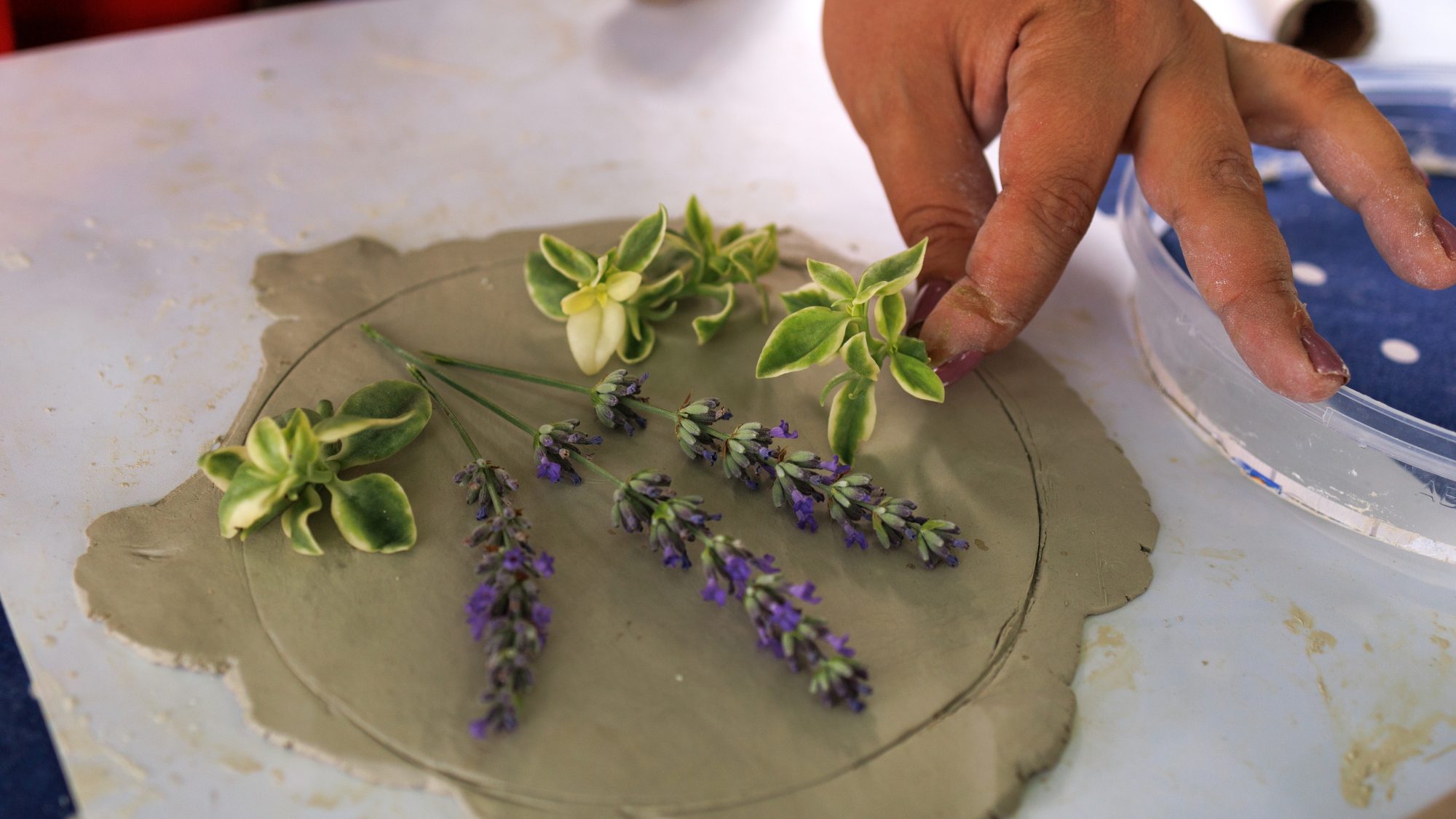 Image showing someone placing flowers onto clay