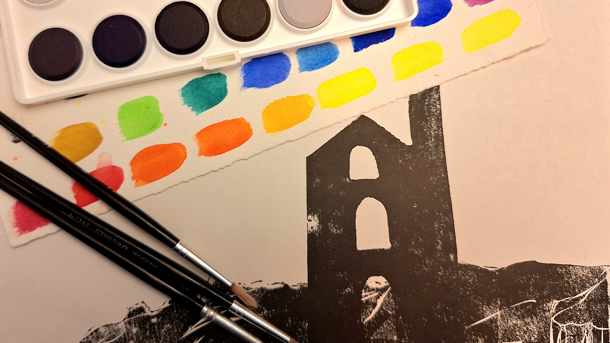 a linocut image of a building with paints and paintbrushes