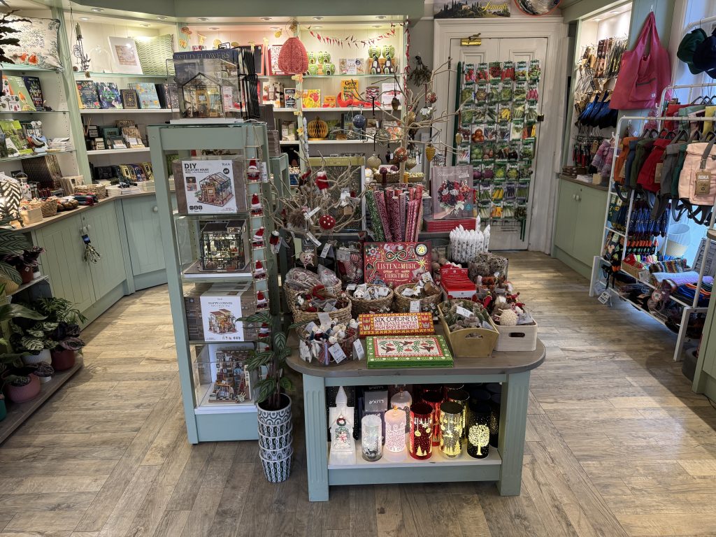 Christmas decorations and gifts fill the inside of a shop.