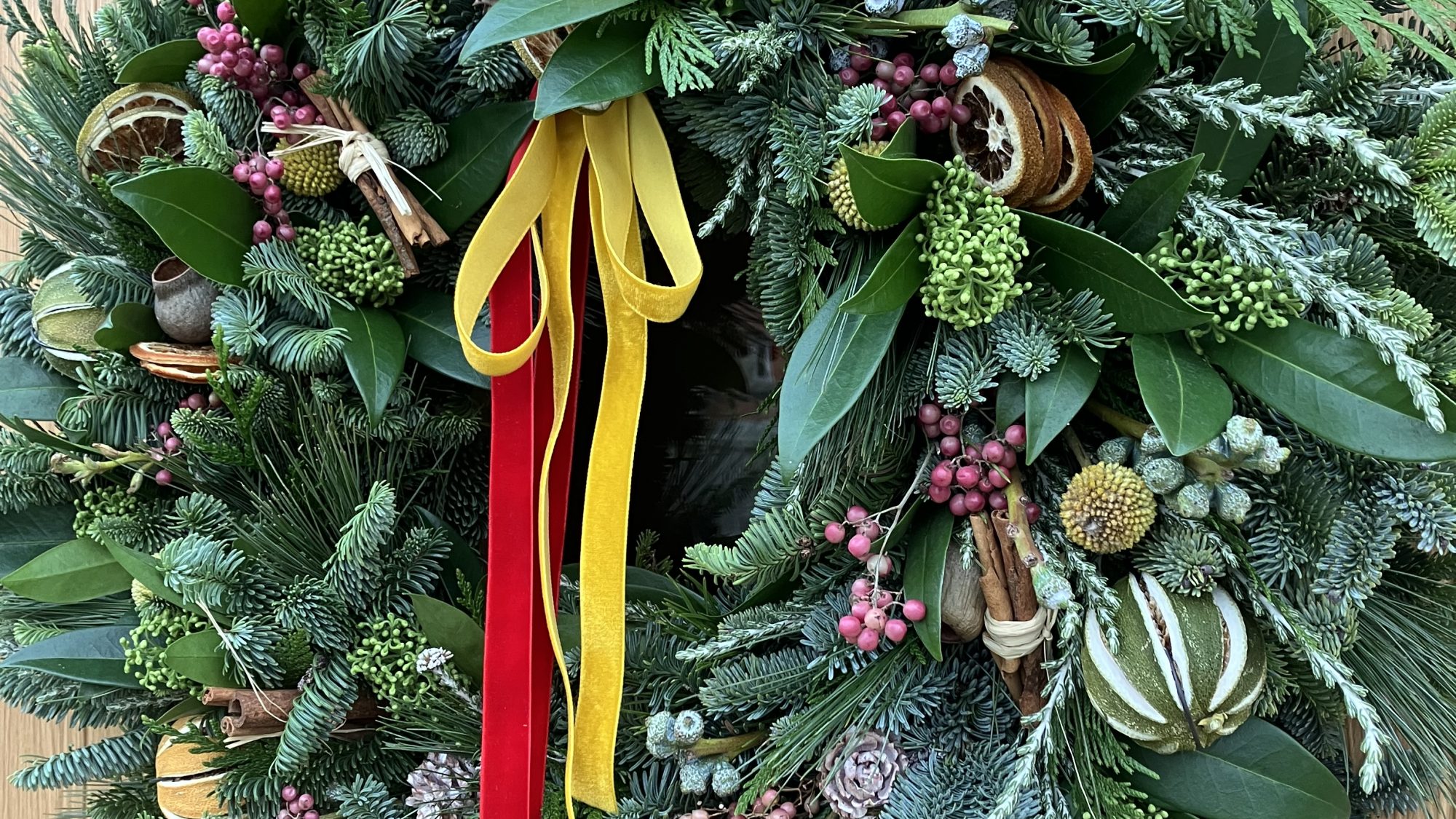 a festive wreath made from spruce, dried fruit, mixed foliage and berries