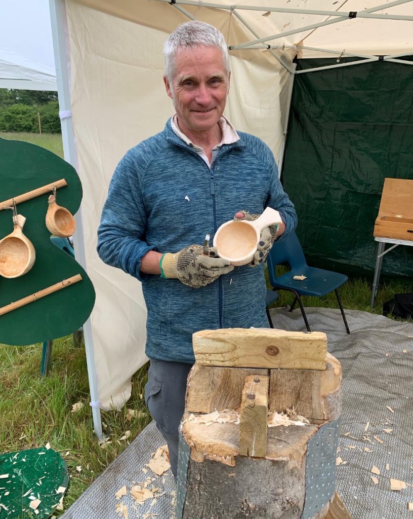 A man holding a hand carved wooden bowl
