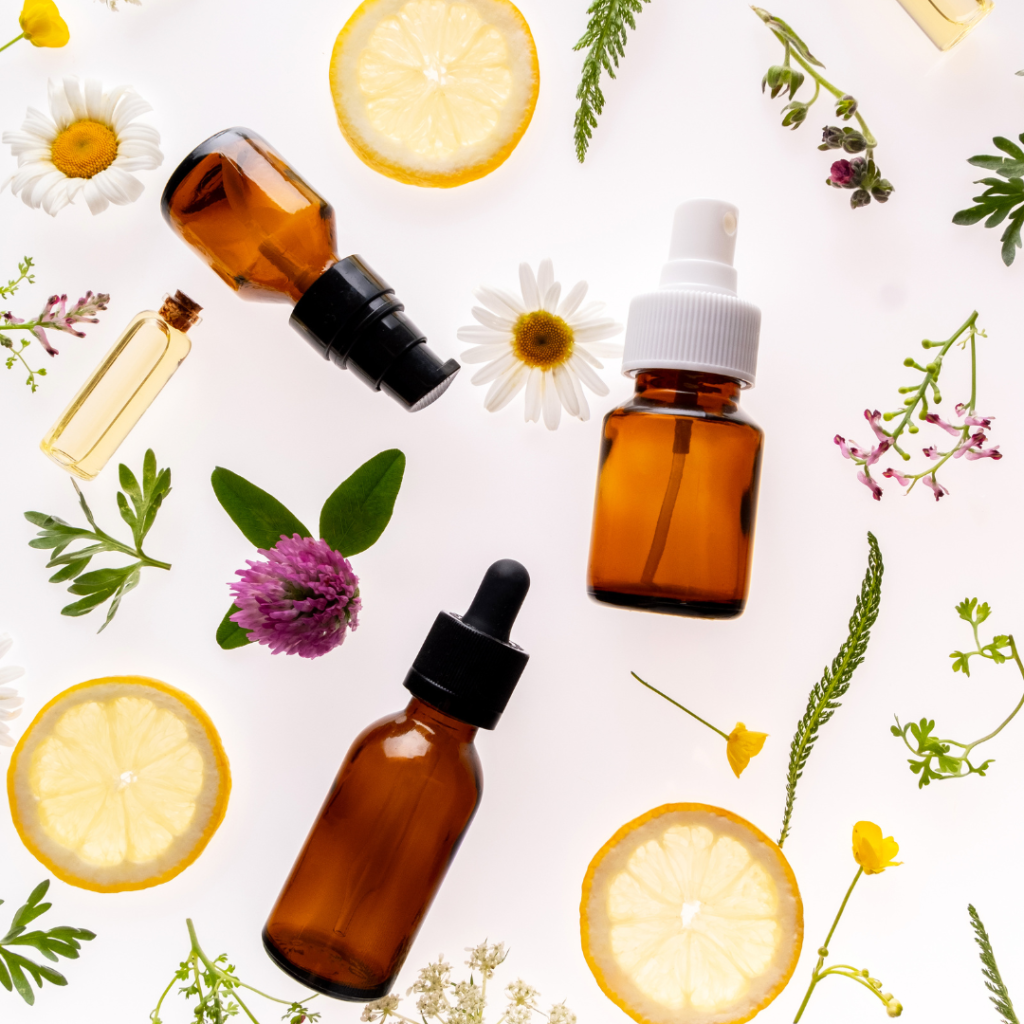 Brown glass bottles surrounded by herbs, flowers and slices of lemon