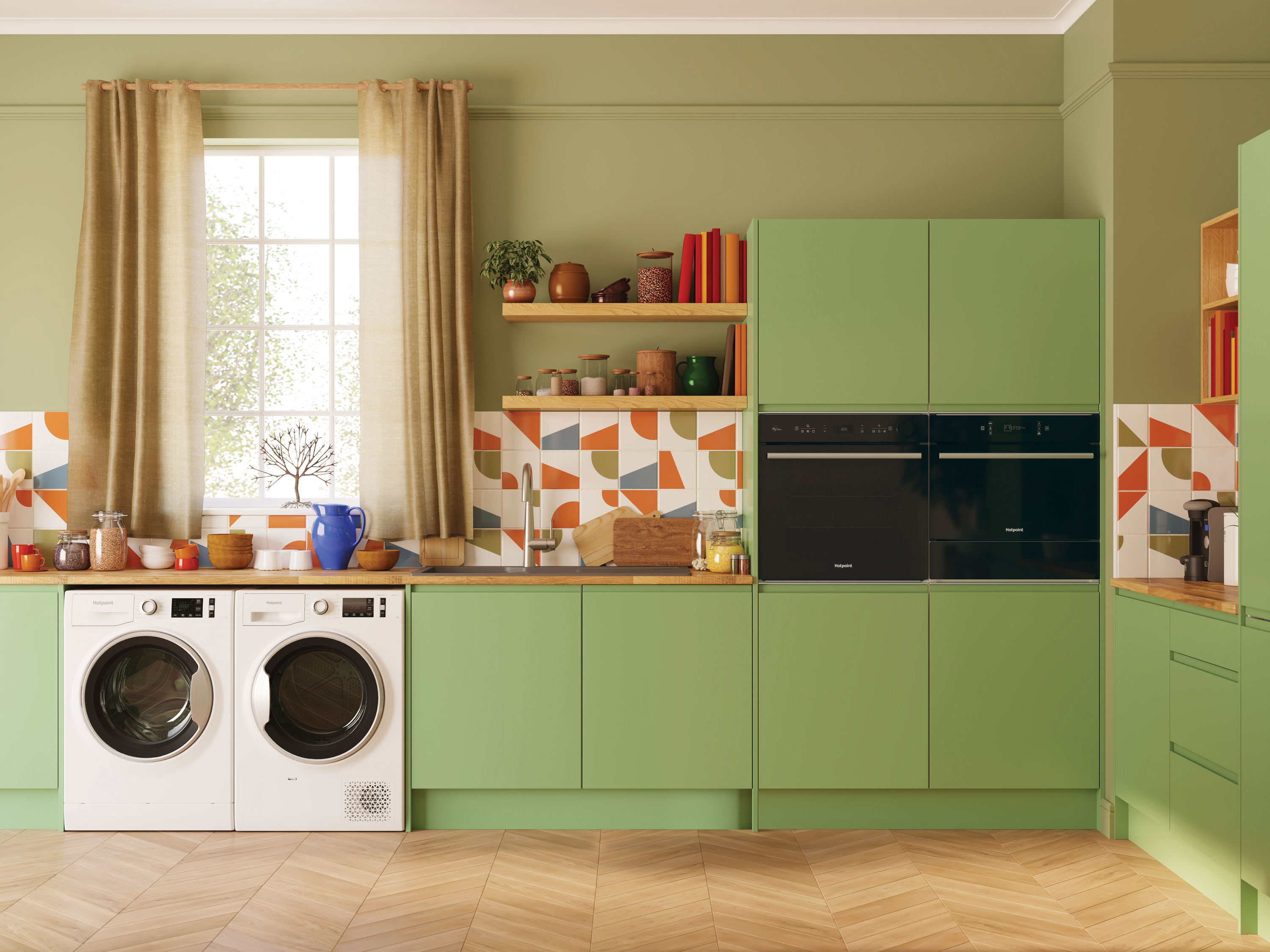 A vibrant green kitchen with wood countertops, black ovens, and a stacked washer and dryer, featuring a colorful geometric backsplash and decorative accents.