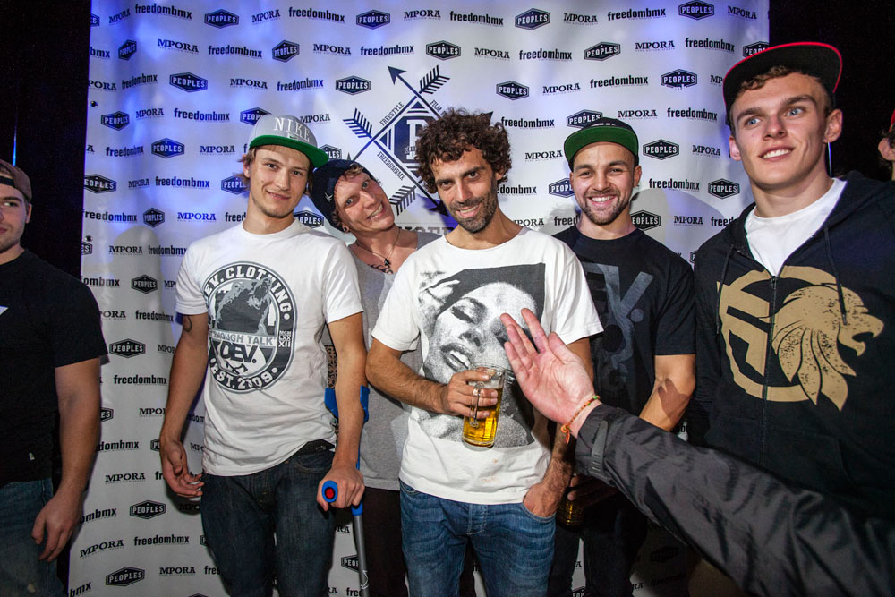 Hat der Herr, der die Hand ins Bild reckt, tatsächlich eine Uhr über der Regenjacke an?