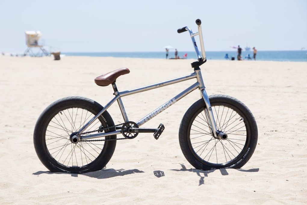 Moritz Nußbaumers wethepeople Buck am Strand von Barcelona mit haufenweise Prototypteilen (Rahmen, Lenker, Vorbau, Kurbel, Naben). Mehr dazu erfährst du auf der wethepeople.de.