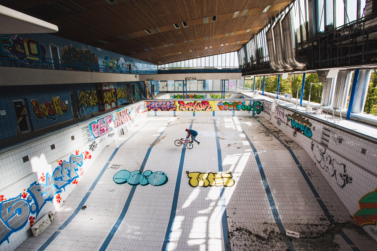 2019 / Daniel Treader / Kiel Ich laufe für mein Leben gerne durch alte Fabriken oder wie in diesem Fall durch ein Schwimmbad. Mitte 2019 war ich mit Daniel Treader in Kiel. Gegenüber von unserem Hostel gab es ein altes Schwimmbad, das gerade abgerissen wurde. Ganz früh am Morgen sind wir dann in das Schwimmbad geklettert und es ist dieses Bild entstanden. Das Foto habe ich vom fünf Meter Sprungturm gemacht. Ohne Wasser im Schwimmbecken fühlte sich das verdammt hoch an. Ich bin im Vierfüßler Gang bis zur Kante gekrochen und habe mich dann auf den Bauch gelegt, um das Foto zu machen.