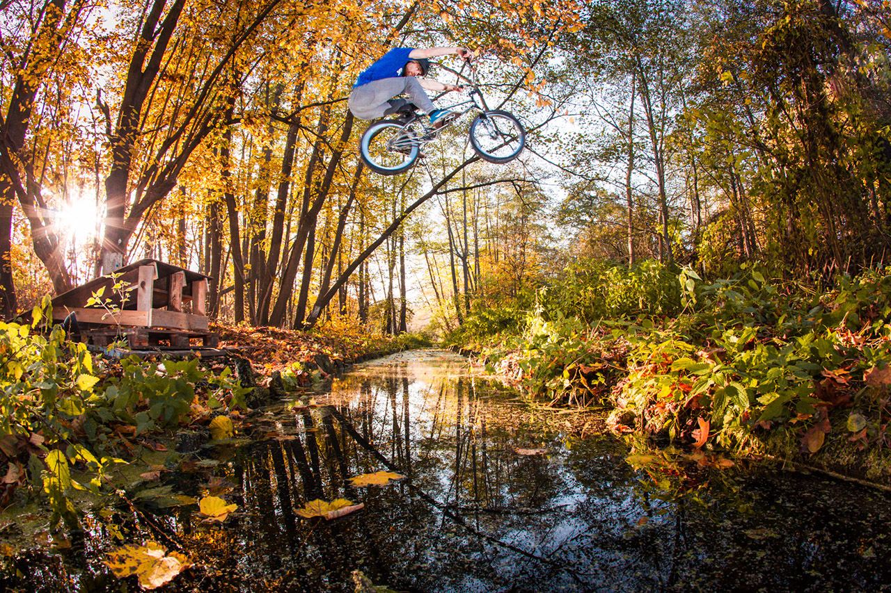 2018 / Daniel Treader / Berlin Ich wollte schon immer ein Bild machen, wo ein BMXer über einen Fluss springt. Für dieses Bild hatte ich mir extra bei einem Verleih ein Unterwasser-Gehäuse ausgeliehen. Ich hatte vor, das Foto aus dem Wasser heraus zu machen, so dass man eventuell auch noch einen Fisch oder Algen Unterwasser sieht. Leider war das Gehäuse nicht richtig dicht und meine Kamera wäre dabei fast kaputt gegangen. Ich bin auch nicht auf die Idee gekommen, das Gebäude mal zu Hause in der Badewanne zu testen. Na ja, herausgekommen ist trotzdem ein tolles Foto, an einem wundervollen Herbstnachmittag. Ich mag besonders die Bewegungsunschärfe vom Fahrrad und im Gegensatz dazu das scharfe Gesicht von Daniel mit dem konzentrierten Gesichtsausdruck.
