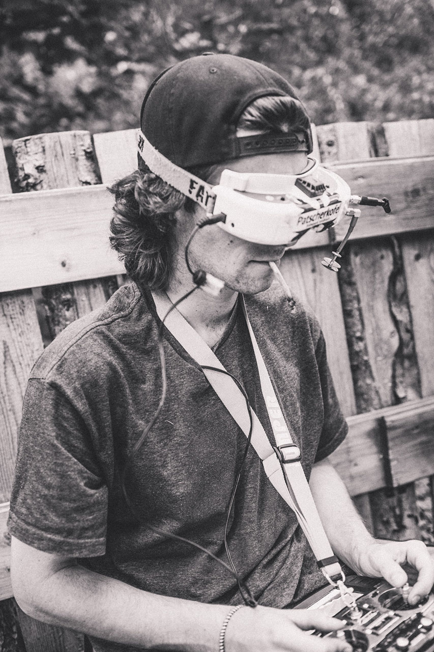 Verrückter Drohnen-Typ, der den ganzen Nachmittag eine Sportzigarette im Mund hatte und FPW Drone hinter den Fahrern geflogen ist