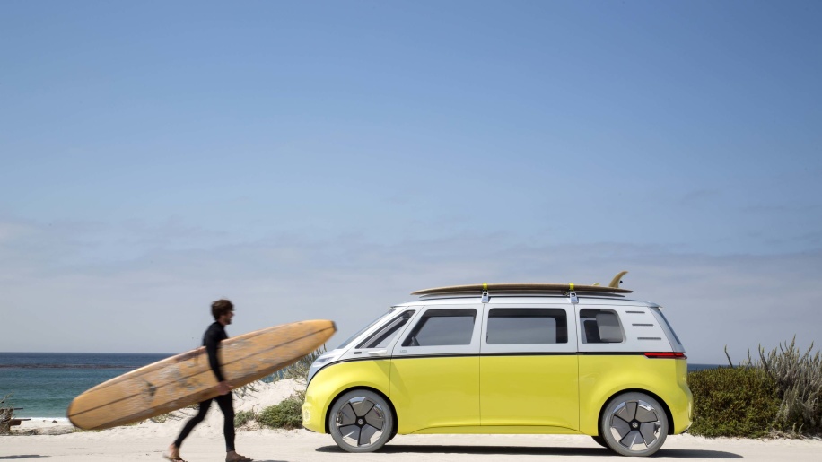 VW Elektro-Bulli am Strand mit Surfer