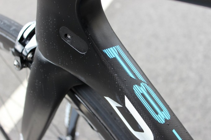 Das Dogma F8 wurde in Zusammenarbeit mit Jaguar entwickelt, wo man sehr weitereichende Erfahrungen in Sachen Aerodynamik vorweisen kann. Das Resultat ist ein Frameset aus recht flachen und dreieckig zulaufenden Profilen (Flatbacks), die schwer an Tragflächen erinnern und den Luftstrom geschickt lenken. Trotz dem neuen Profil kann Pinarello die hohen Steifigkeitswerte der Oversized-Rahmen mitgehen. Auf dem Bild erkennt man den Zugeinlass für mechanische Schaltungen.