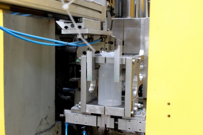 Heißer, flüssiger Kunststoff wird in eine Gussform gefüllt und in Form gepresst. Anschließend wird die Flasche sofort gekühlt und überschüssiges Material entfernt.