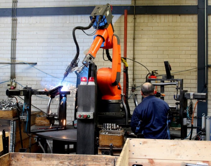 Beim Schweißen der Stahlrahmen für die Heimtrainer arbeiten Mensch und Maschine zusammen.