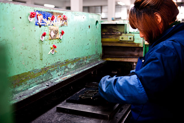 Diese sogenannten Cutting Molds werden von einer Arbeiterin routiniert auf einen Stoffstapel gelegt und in eine Maschine geschoben, welche die Metallform dann in den Stoff hineindrückt und diesen so zurechtschneidet. Wie fast überall in der Handschuhproduktion ist auch hier akkurates Arbeiten oberste Priorität. Die Molds müssen so angeordnet werden, dass der Stoff optimal ausgenutzt wird und möglichst wenig Ausschussmaterial entsteht. Bei den abertausenden Gloves, welche die Fabrik jedes Jahr in alle Welt verlassen, zählt jeder Quadratzentimeter Stoff, der nicht verschwendet wird.