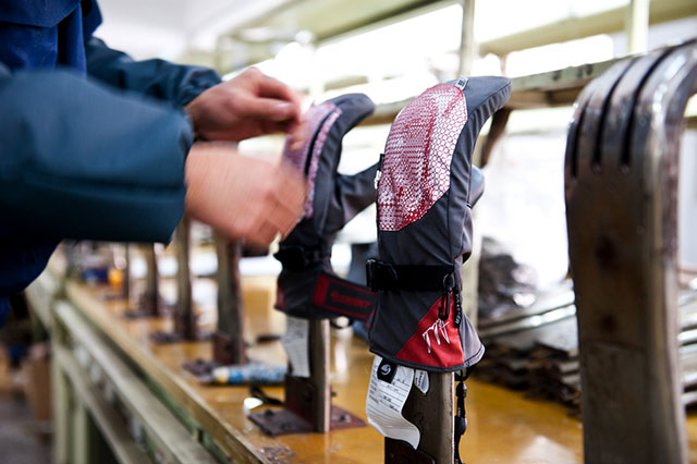 Nachdem Innen- und Aussenhandschuh schliesslich ineinander gelegt wurden, stülpen die Arbeiterinnen den an sich fertigen Handschuh von innen nach aussen. Der Glove wird dann zum Glätten und Anpassen der endgültigen Form noch über ein 70° Celsius heisses Eisen gelegt. 