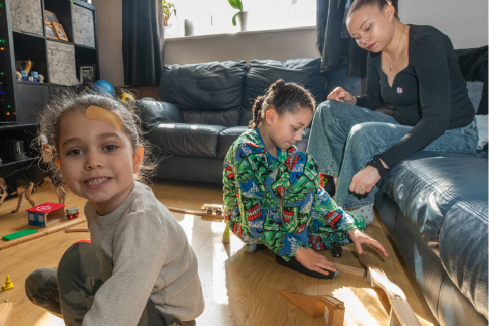 A mum with two kids playing in the living room