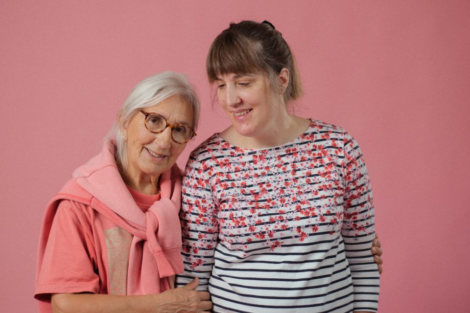 Smiling mother and daughter with arms linked