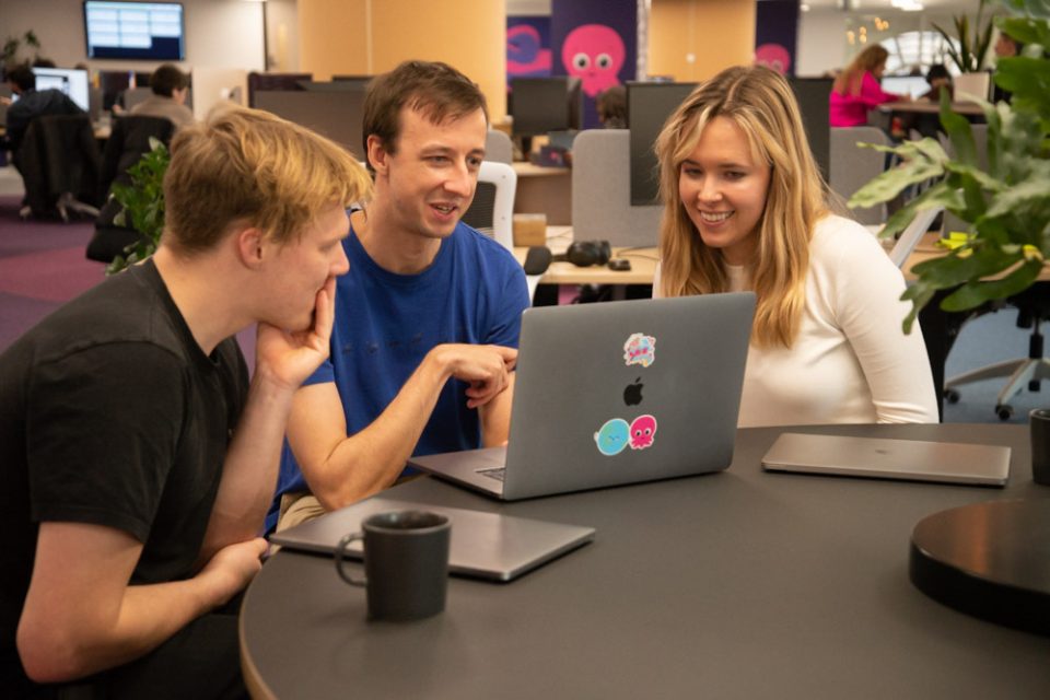 neurodiversity at work consultancy: three colleagues collaborate as they sit around a computer together