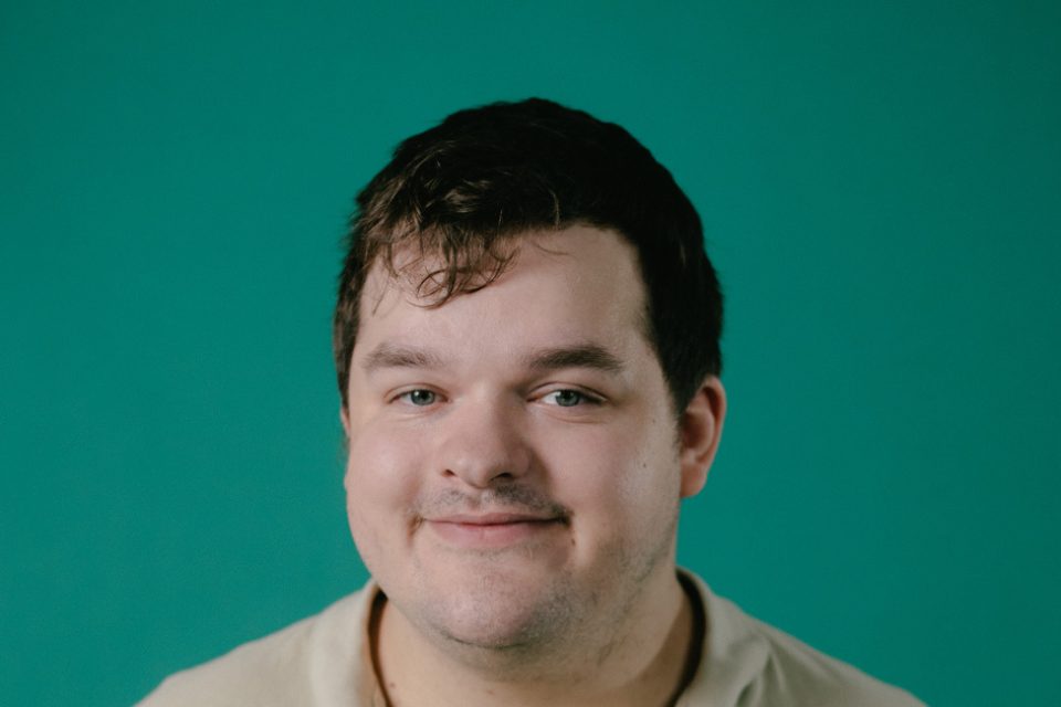 Autistica tips hub: a smiling white man with a green backdrop