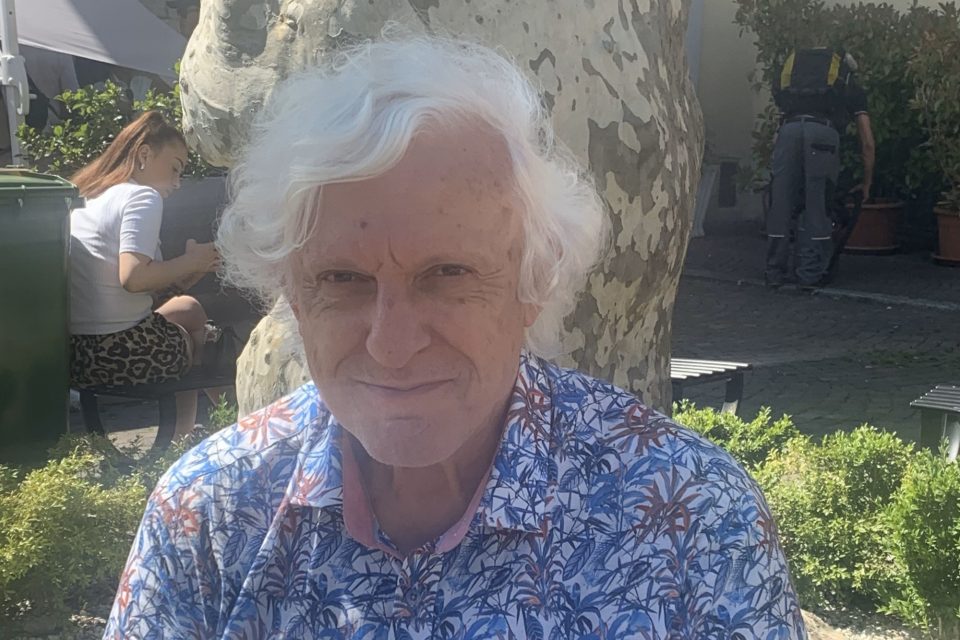 David smiling while seated in a garden