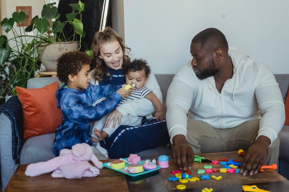 A young family playing with a toddler