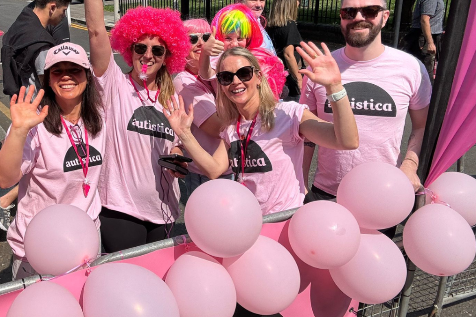A cheering group of people in pink autistic at-shirts