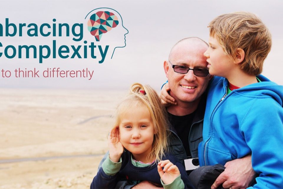 Embracing Complexity: A son hugs his two children.